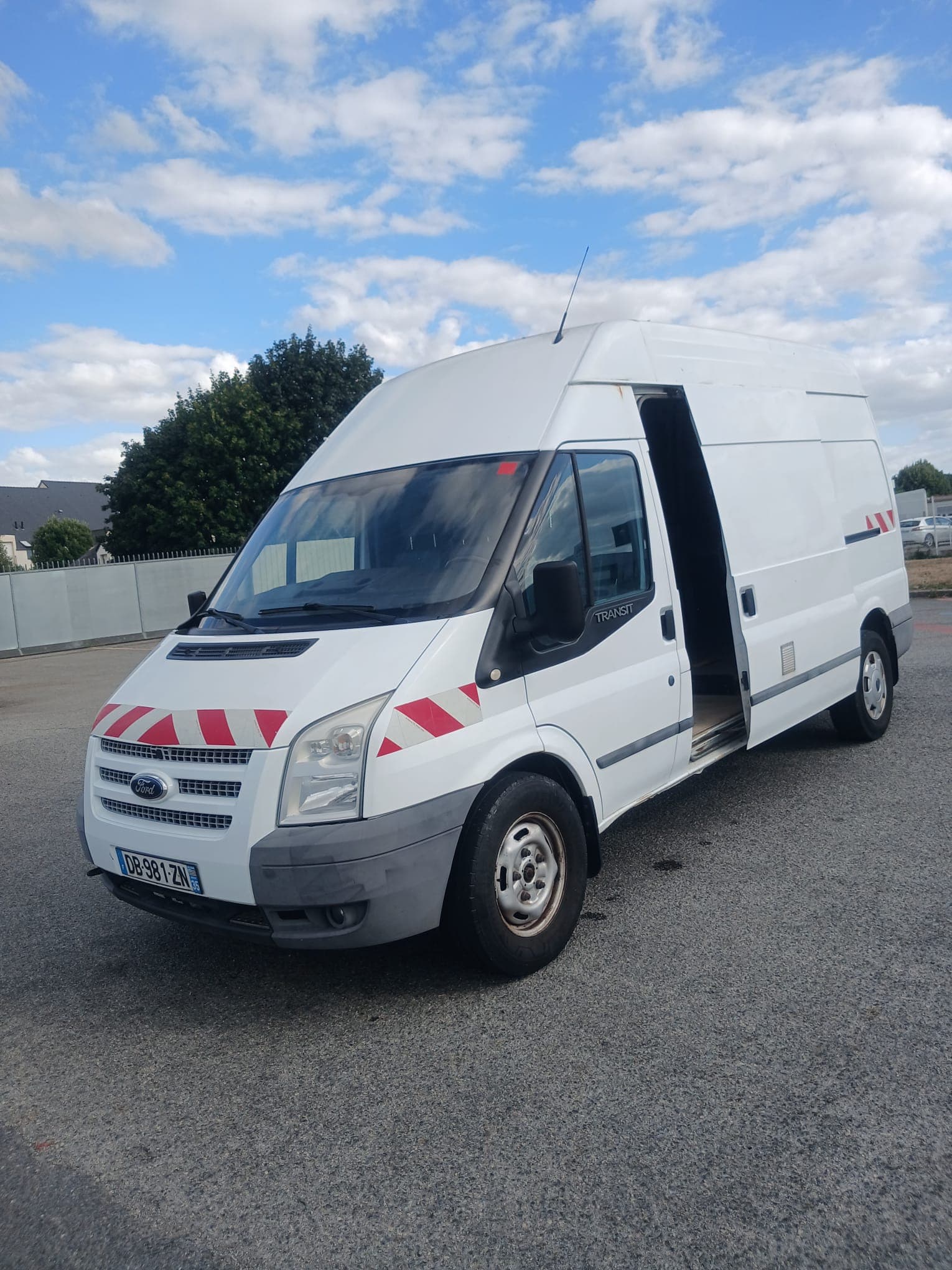 Utilitaire Ford Transit blanc de Francis Location vu de trois quarts avant, porte latérale ouverte